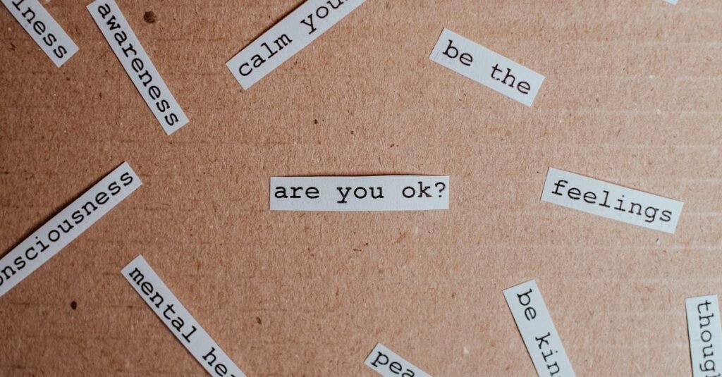 O Que É Terapia Focada na Compaixão? Cut-out words promoting mental health awareness on cardboard background.